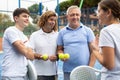 Four paddle tennis players talking on court Royalty Free Stock Photo