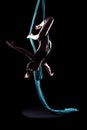 Young woman gymnast with blue gymnastic aerial silks