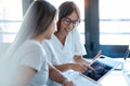 Young woman gynecologist doctor showing to pregnant woman ultrasound scan baby with digital tablet in medical consultation Royalty Free Stock Photo