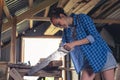 A young woman with a hacksaw in her hands sawing boards in the home workshop Royalty Free Stock Photo