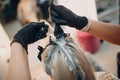 Young woman hairdresser dying hair at beauty salon. Professional hair roots coloring Royalty Free Stock Photo