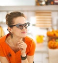 Young woman in Halloween decorated kitchen looking aside