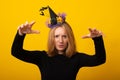 Young woman in a Halloween evil witch costume, dressed in a black dress with a witch hat. Halloween party girl