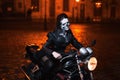 Young woman with Halloween makeup sitting on the motorbike . Street portrait