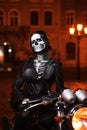 Young woman with Halloween makeup sitting on the motorbike . Street portrait