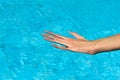 Young woman hand in blue water in a swimming pool horizontal Royalty Free Stock Photo