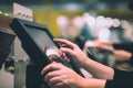 Young woman hand doing process payment on a touchscreen cash register, POS, finance concept