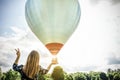 Young woman hand holding balloon with sunset light on sky background - Travel,freedom and peace concept - Focus on right hand - Royalty Free Stock Photo