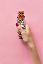 Young woman hand holding cereal bar on pastel pink background. Sweet healthy food Royalty Free Stock Photo