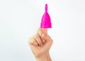 Young woman hand holding a pink menstrual cup