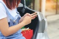 Young woman hand holding smartphone and shopping bags with standing at the car parking lot, shopping concept Royalty Free Stock Photo