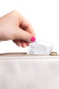 Young woman hand pulling a condom from a  leather bag, white background Royalty Free Stock Photo