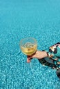 Young woman hand with red manicure holds a glass of champagne. Wine cocktail with lemon wedges Royalty Free Stock Photo