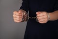 Young woman handcuffs in criminal concept