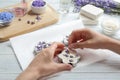 Young woman  handmade soap bar with lavender flowers on white wooden background, closeup Royalty Free Stock Photo