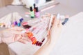 Young woman hands choosing nail color. Female manicured hands and nail color samples