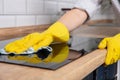 Young woman hands cleaning a modern black induction hob by a rag, housework Royalty Free Stock Photo