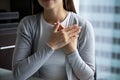 Young woman hands folded on chest expressing heartfelt thank you