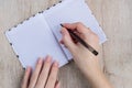 Young woman hands hold opened notebook pages with black pen on  wooden table Royalty Free Stock Photo