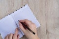 Young woman hands hold opened notebook pages with black pen on  wooden table Royalty Free Stock Photo