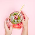 Young woman hands holding freshly squeezed watermelon lemonade of citrus fruits. Female with mason jar full of cold cocktail, mint Royalty Free Stock Photo
