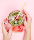 Young woman hands holding freshly squeezed watermelon lemonade of citrus fruits. Female with mason jar full of cold cocktail, mint Royalty Free Stock Photo