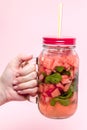 Young woman hands holding freshly squeezed watermelon lemonade of citrus fruits. Female with mason jar full of cold cocktail, mint Royalty Free Stock Photo