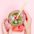 Young woman hands holding freshly squeezed watermelon lemonade of citrus fruits. Female with mason jar full of cold cocktail, mint Royalty Free Stock Photo