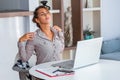 Young woman with hands holding her shoulder pain. Office syndrome and Health care concept. Business woman working with her laptop Royalty Free Stock Photo