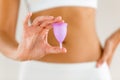 Young woman hands holding menstrual cup on the bathroom.