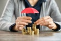 Hands protecting pile of coins with umbrella Royalty Free Stock Photo