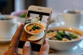 Young woman hands make photo of pumpkin and carrot soup. Take social networks smartphone food photography. Royalty Free Stock Photo