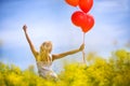 Young woman with hands raised on spring field of yellow flowers Royalty Free Stock Photo