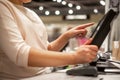Young woman hands scaning, entering discount, sale on a receipt, touchscreen cash register, shop, finance concept