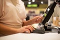 Young woman hands scaning, entering discount, sale on a receipt, touchscreen cash register, market shop