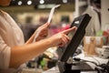 Young woman hands scaning, entering discount, sale on a receipt, touchscreen cash register