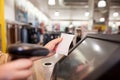 Young woman hands scanning a bill payment for a customer at huge shopping center, finance concept