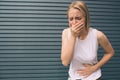 Young woman with hands on stomach having bad aches pain on gray background. Food poisoning, influenza, cramps Royalty Free Stock Photo