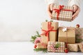 Young woman hands taking a gift box from a big stack of gifts