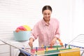 Young woman hanging clean laundry on drying rack indoors Royalty Free Stock Photo