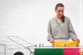 Young woman hanging clean laundry on drying rack indoors