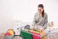 Young woman hanging clean laundry on drying rack indoors Royalty Free Stock Photo