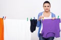 Young woman is hanging clothing on clothesline on white background Royalty Free Stock Photo