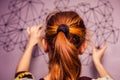 Young woman hanging a piece of art on her wall Royalty Free Stock Photo