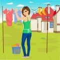 Young woman hanging wet clothes out to dry next to family house Royalty Free Stock Photo