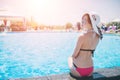 Young woman happy in big hat relaxing on the swimming pool, travel near the beach in the sunset. Concept summer Royalty Free Stock Photo