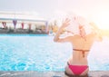 Young woman happy in big hat relaxing on the swimming pool, travel near the beach in the sunset. Concept summer Royalty Free Stock Photo