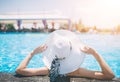 Young woman happy in big hat relaxing on the swimming pool, travel near the beach in the sunset. Concept summer Royalty Free Stock Photo