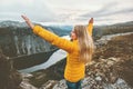 Young woman happy raised hands on mountain top