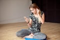 Young woman happy singing her favorite song while listening music sitting on the floor. Royalty Free Stock Photo